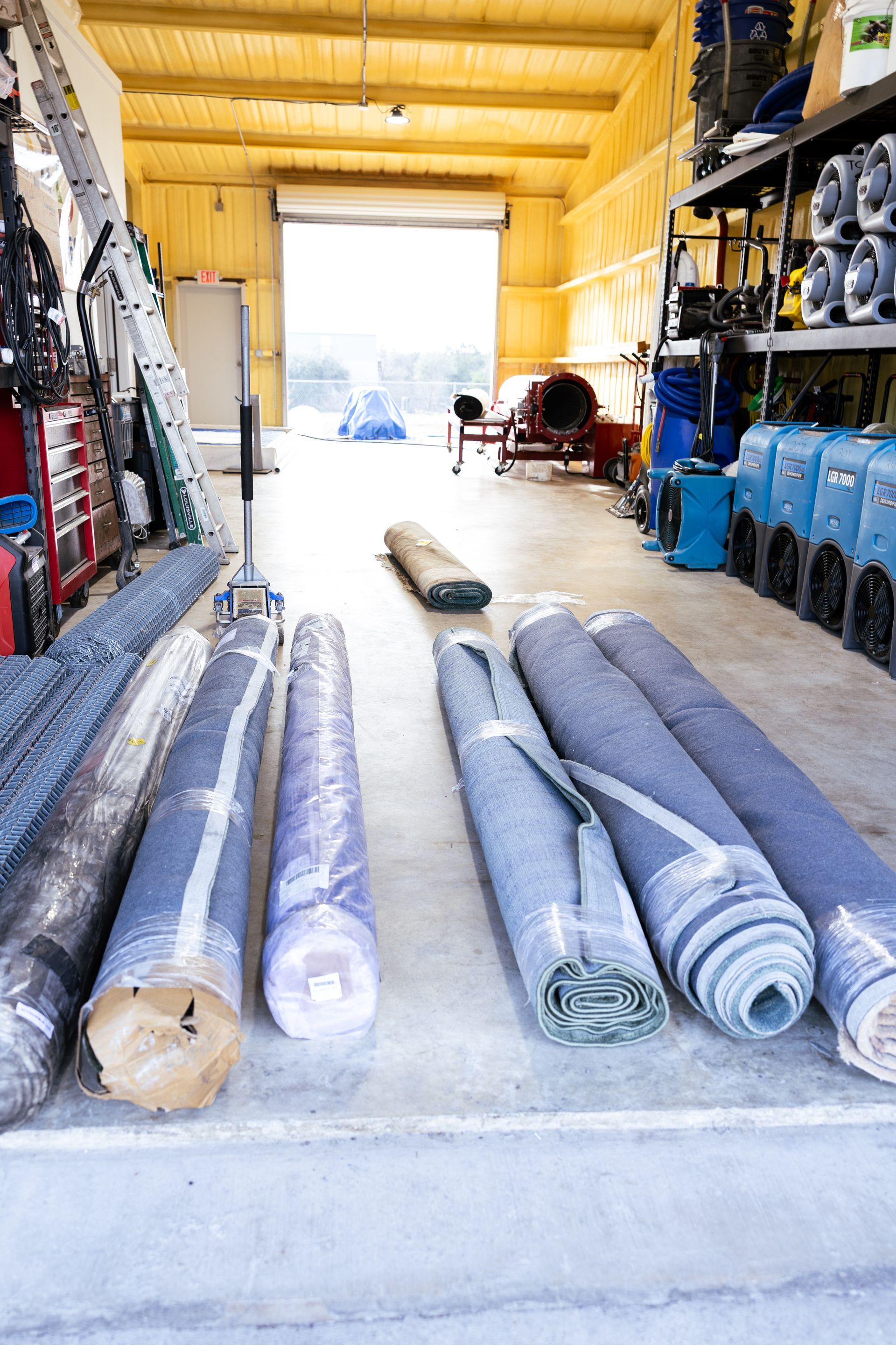 Cleaned area rugs rolled and wrapped for return to their owners